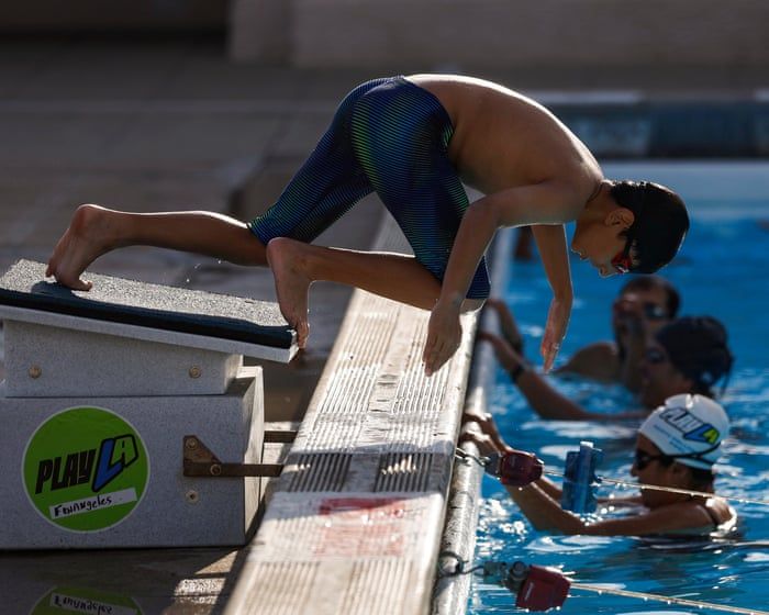 Families seek refuge in a pool at the North Hollywood recreation center in Los Angeles during July heat. - Chris Torres/EPA