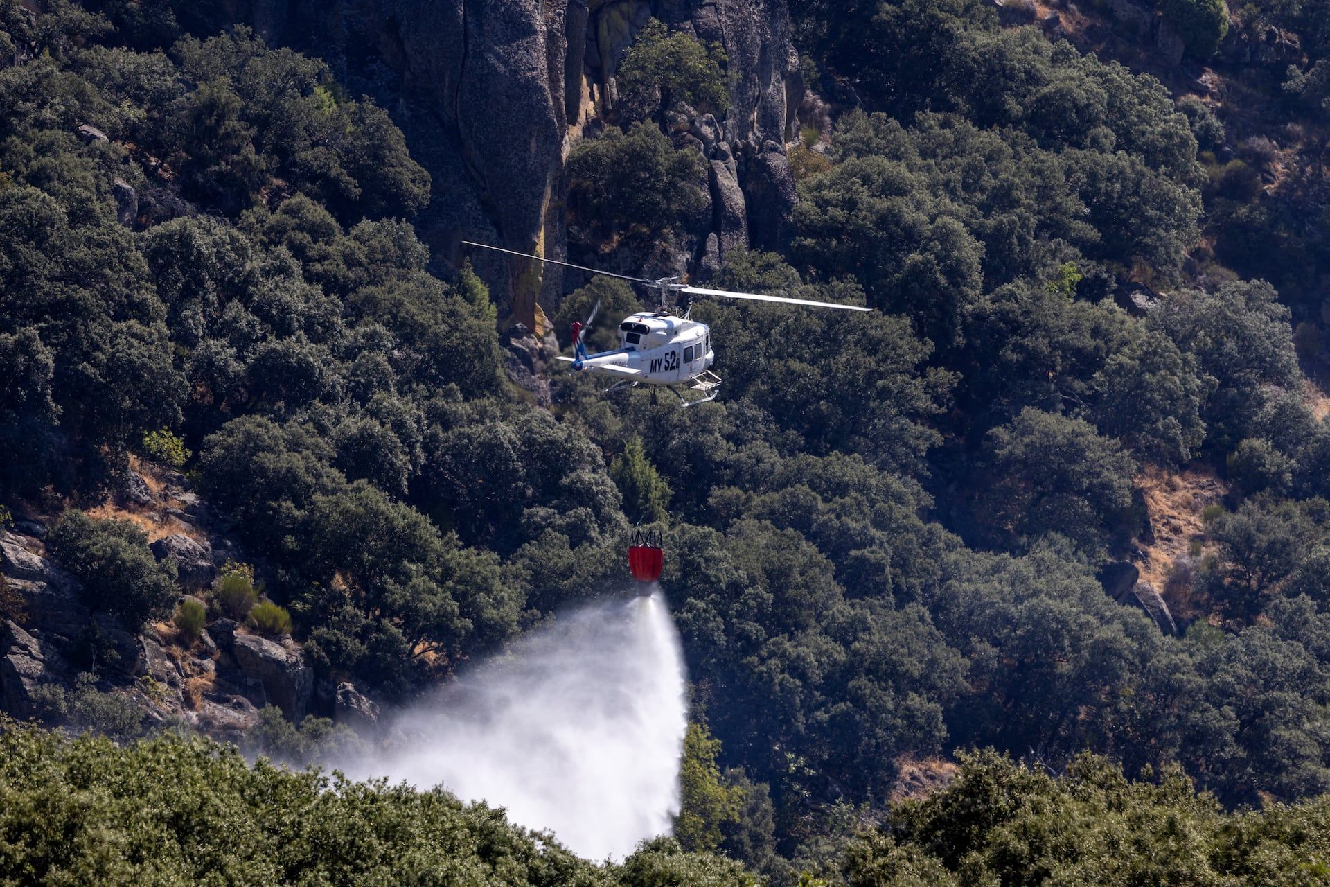 A firefighting helicopter drops water near Fermoselle during a wildfire in Spain on July 30, 2026. - REUTERS/Umit Bektas