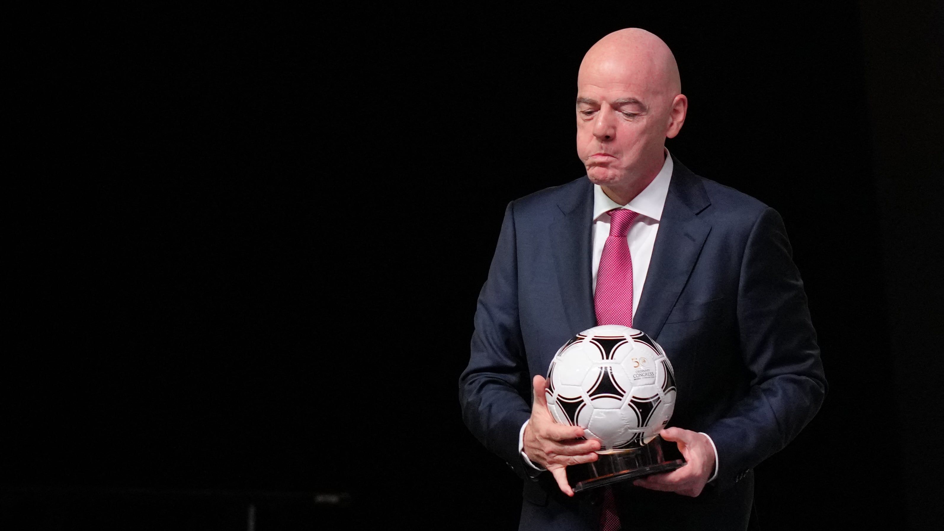 FIFA President Gianni Infantino holds a commemorative football after addressing the 50th UEFA Ordinary Congress in Brussels on February 12, 2026. - Pau Barrena / AFP