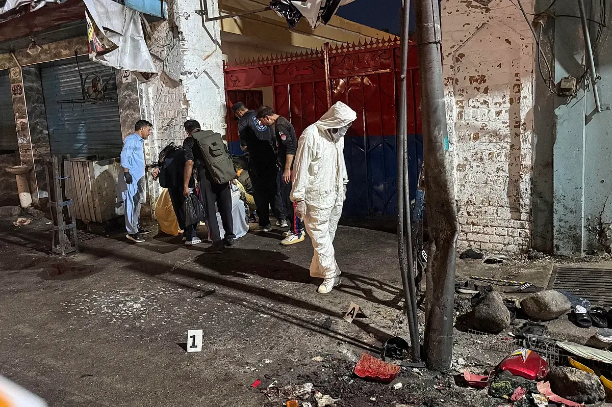 Police officials inspect the site following a suicide bombing during a protest in Pakistan's Swat district on August 2, 2026. - AFP