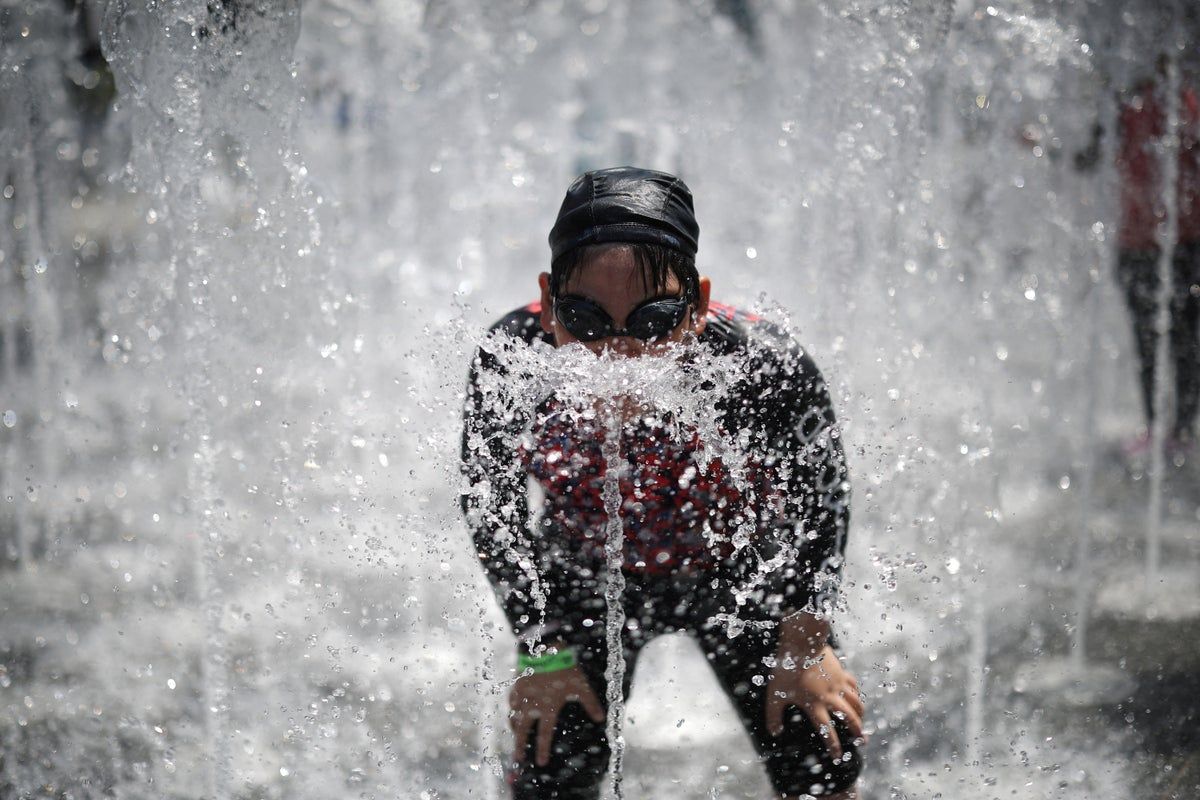A boy plays at a ground fountain during a heatwave in central Seoul, South Korea. - Reuters
