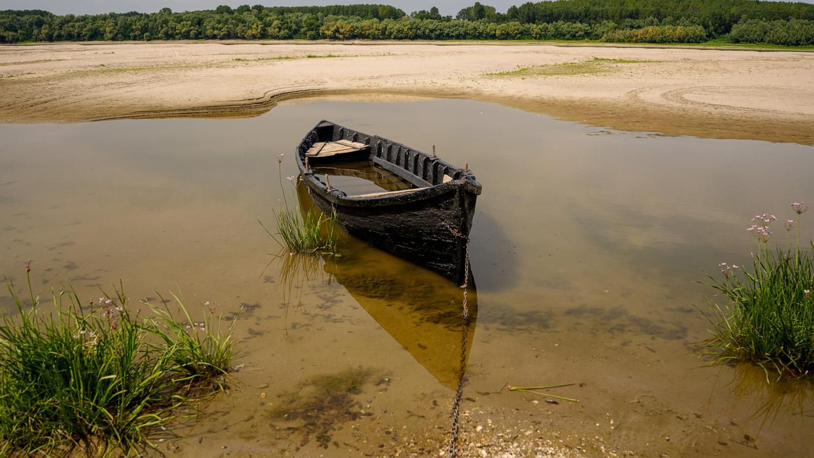 A boat rests on exposed sand along the Danube River during low water levels in Rasova, Romania, on Aug. 3, 2026. - AP Photo/Andreea Alexandru