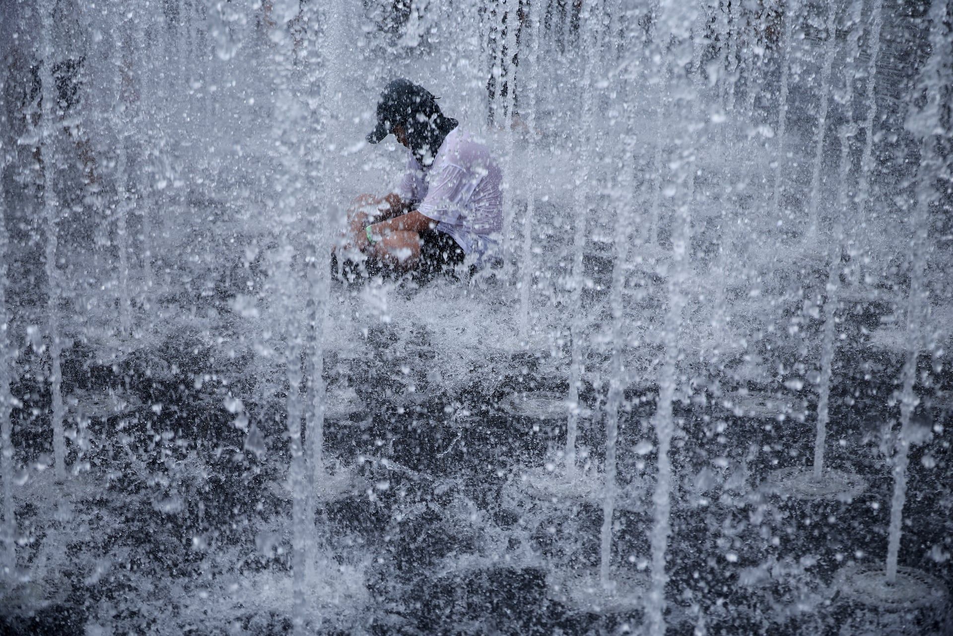 A boy cools down at a ground fountain during a heatwave warning in Seoul, South Korea, August 3, 2026. - REUTERS/Kim Hong-Ji