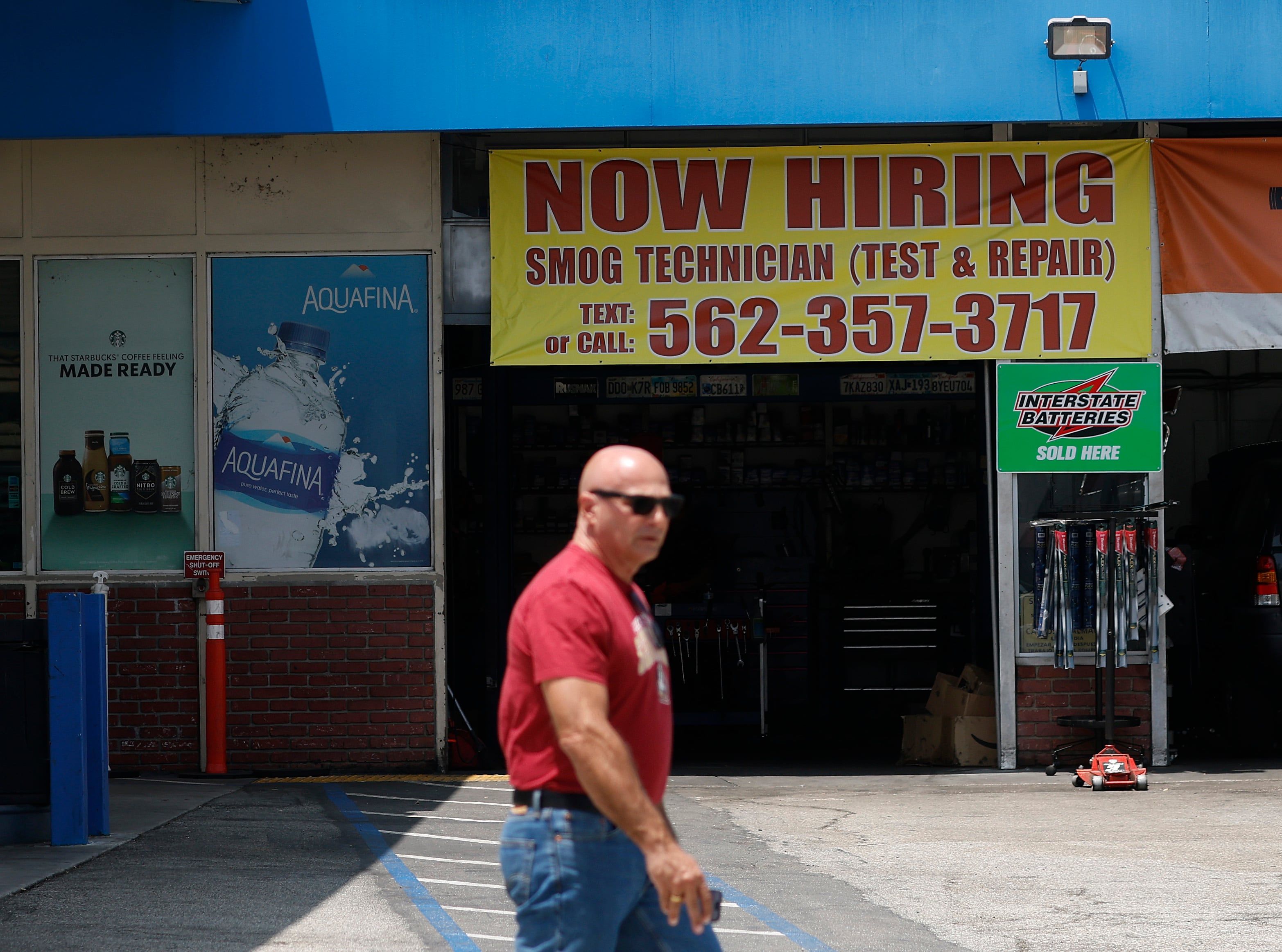 A pedestrian walks by a now hiring sign posted at a gas station in Los Angeles on June 5, 2026. - Justin Sullivan/Getty Images