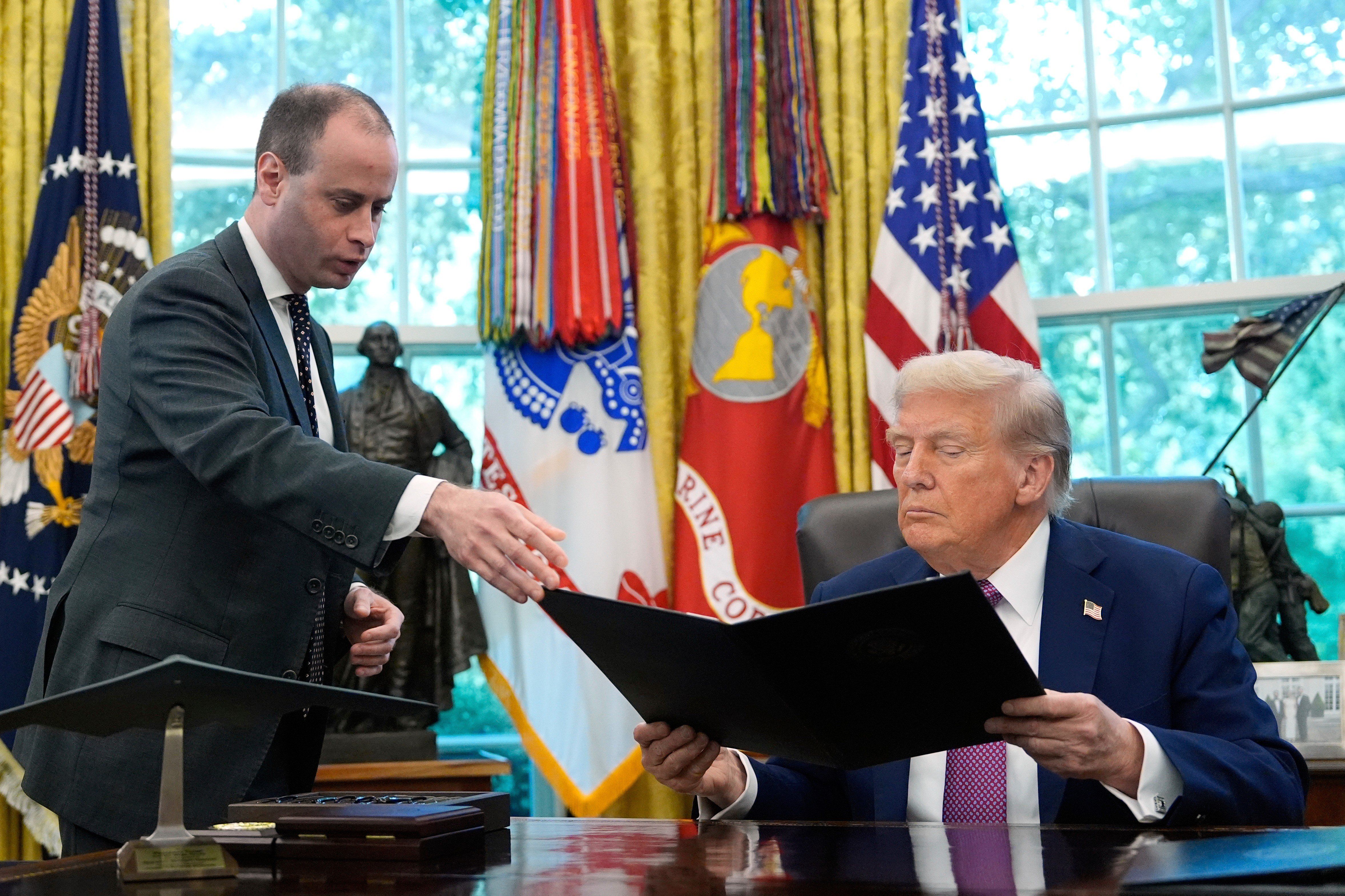 White House staff secretary Will Scharf, left, hands President Donald Trump an executive order to sign in the Oval Office of the White House on Sept. 5, 2025, in Washington. - AP Photo/Alex Brandon