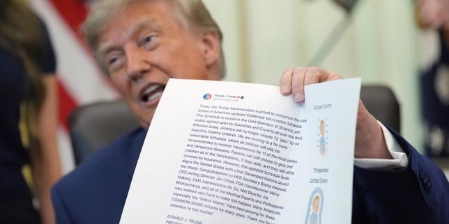 President Donald Trump holds up an image from his Truth Social account during an Oval Office event on Aug. 10, 2026. - lemonde.fr
