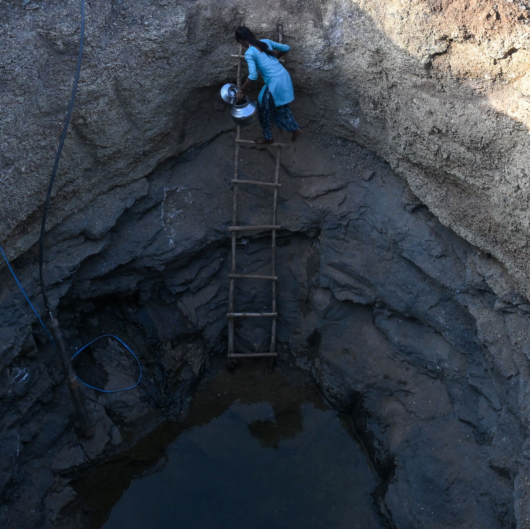 Collecting water from a well in a drought-afflicted village in India. - nytimes.com