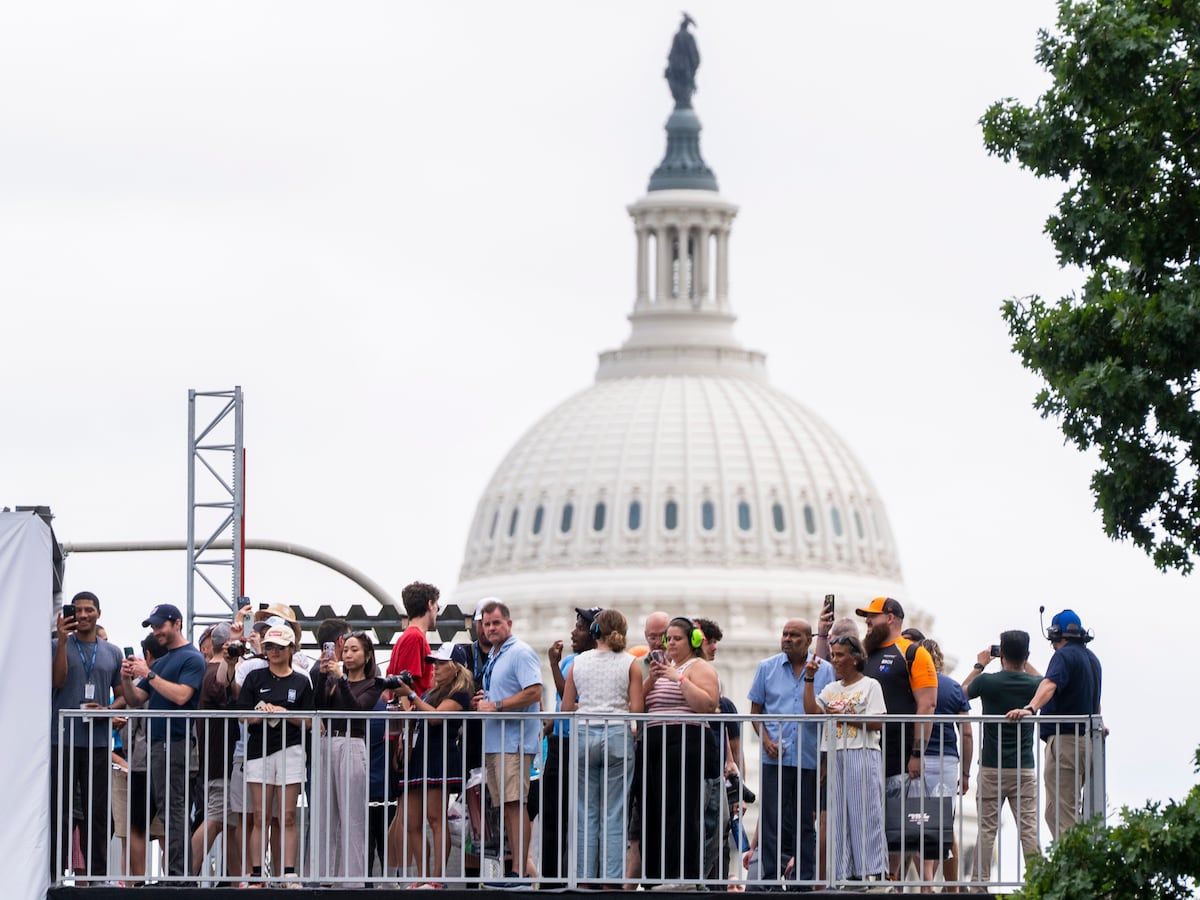 Spectators watch from an overpass near the U.S. Capitol as drivers take practice runs along Pennsylvania Avenue before the Freedom 250 Grand Prix. - AP Photo/Manuel Balce Ceneta