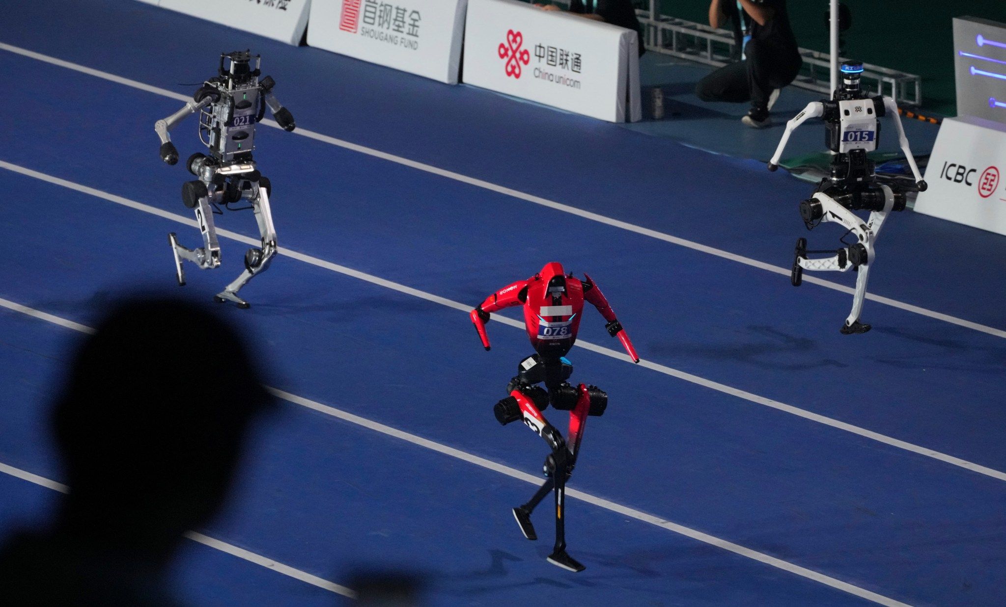 Robots compete in the 100m race during the opening ceremony of the World Humanoid Robot Games in Beijing, Saturday, Aug. 22, 2026. - AP/Achmad Ibrahim