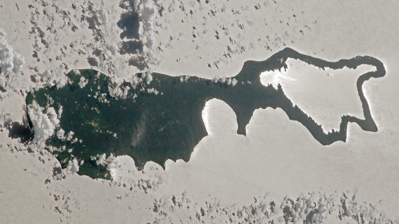 When sunlight reflects off a body of water directly into a camera in low Earth orbit, it transforms the water's surface into a silvery mirror. That is exactly what happened in this 2023 astronaut photo of Rennell Island. - NASA/ISS program