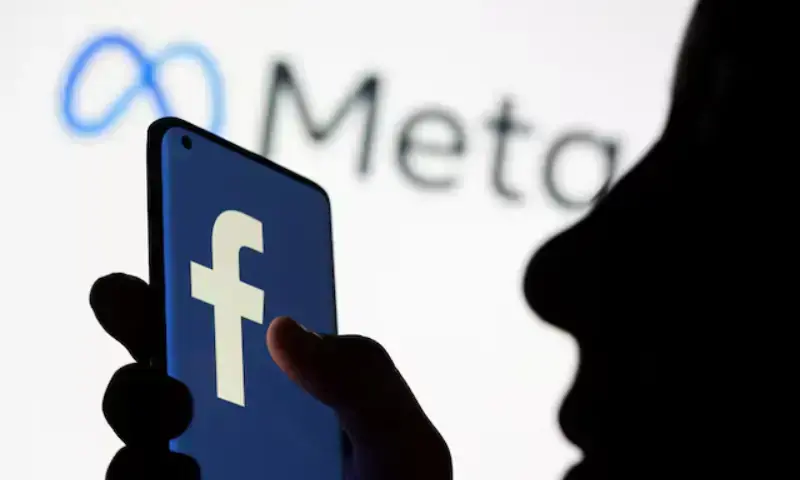 Woman holds smartphone with Facebook logo in front of a displayed logo for Meta in this illustration picture taken on October 28, 2021. - Reuters/File Photo