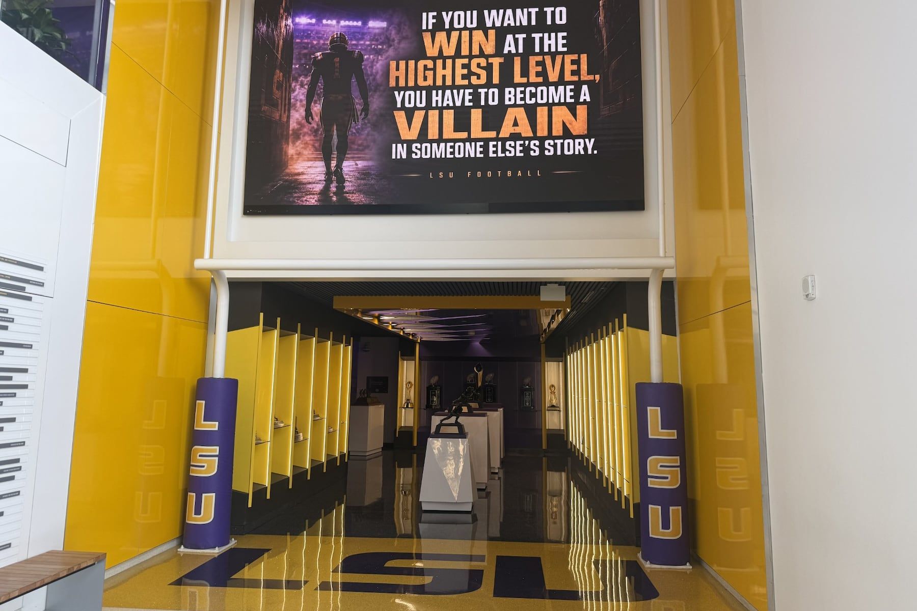 A quote hangs above a trophy display room near the entrance of the LSU Football Operations Center Monday, Aug. 31, 2026, in Baton Rouge, La. - AP Photo/Brett Martel
