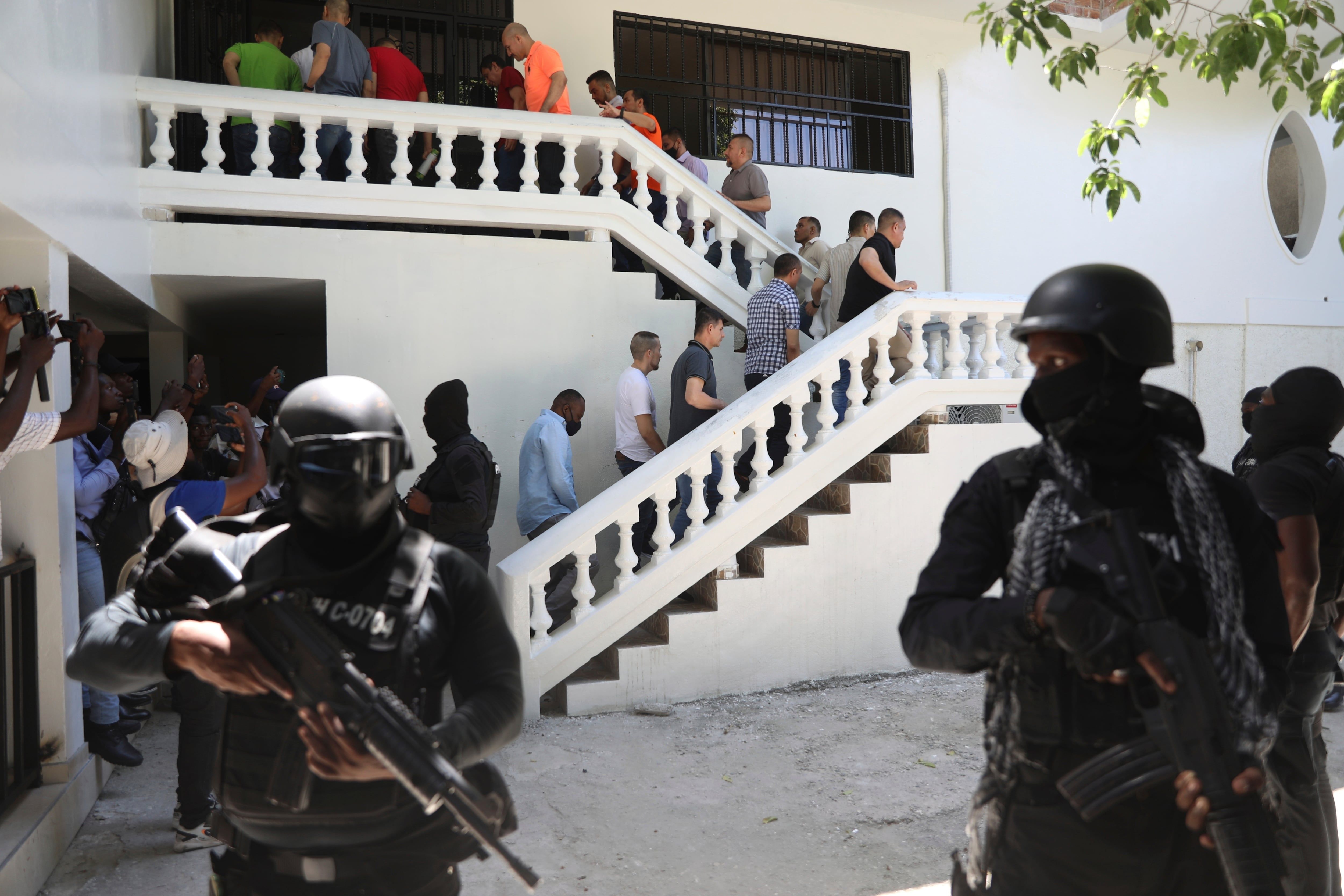 Accused Colombians and Haitians are escorted in handcuffs to a court hearing in Port-au-Prince on May 26, 2025. - Odelyn Joseph/AP