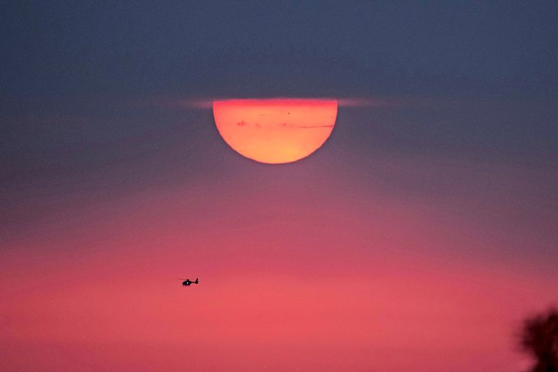A woman shelters from the sun with a parasol in Seville, Spain, during a 2026 heat wave. - derstandard.at