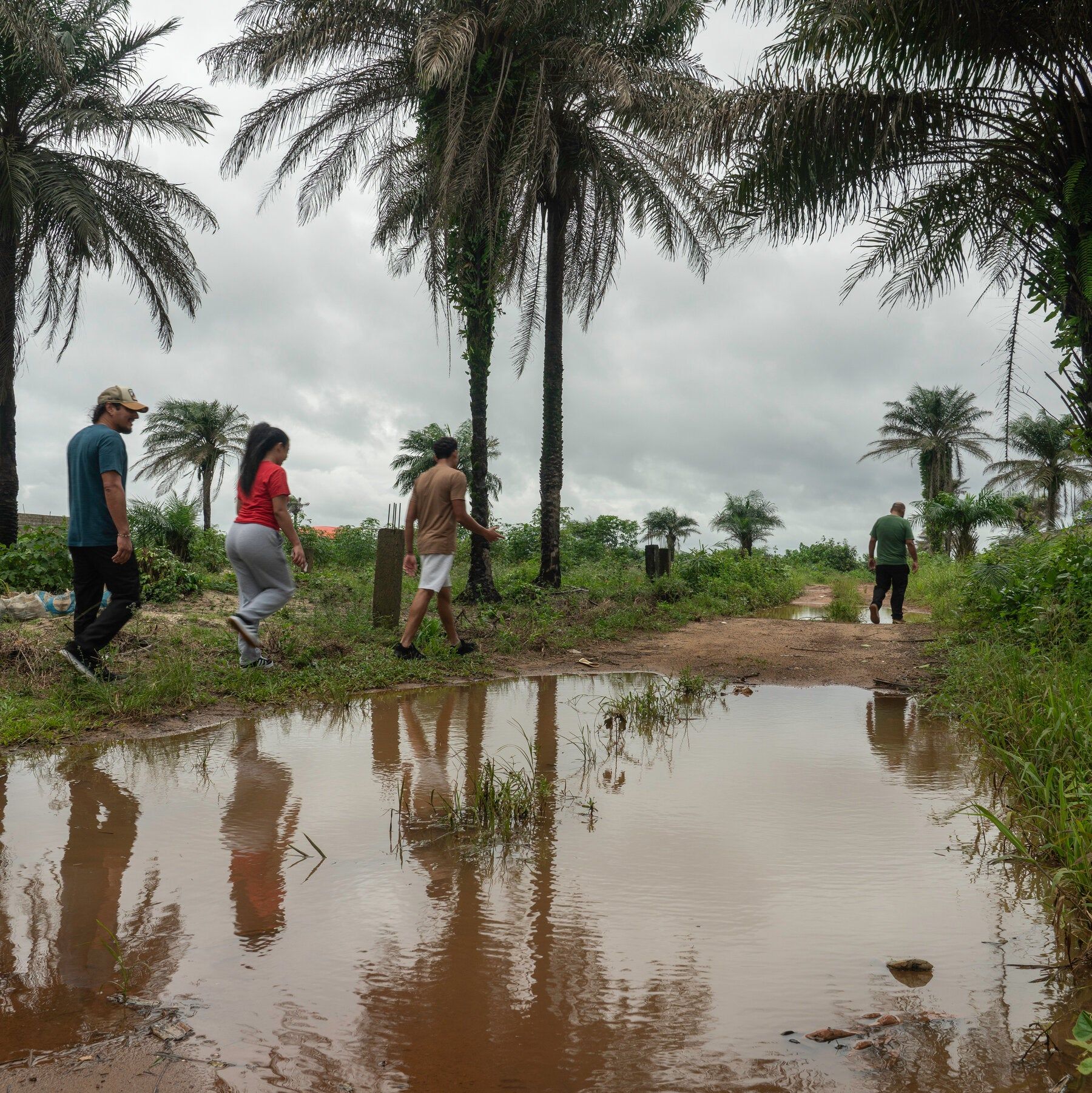 People in the first group sent from the United States to Liberia under a third-country deportation arrangement walk on a beach in Marshall, Liberia. - nytimes.com