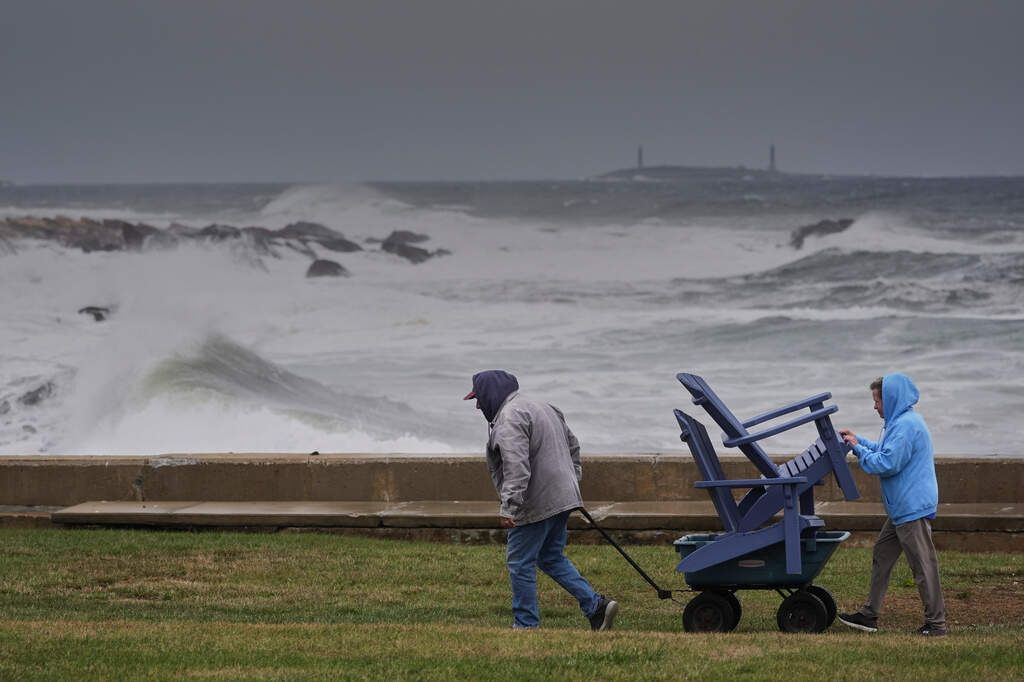 Chuck and Teresa Palmieri move lawn furniture at a seaside property as surf rises during the nor’easter in Gloucester, Massachusetts, on Sept. 25, 2026. - Robert F. Bukaty/AP
